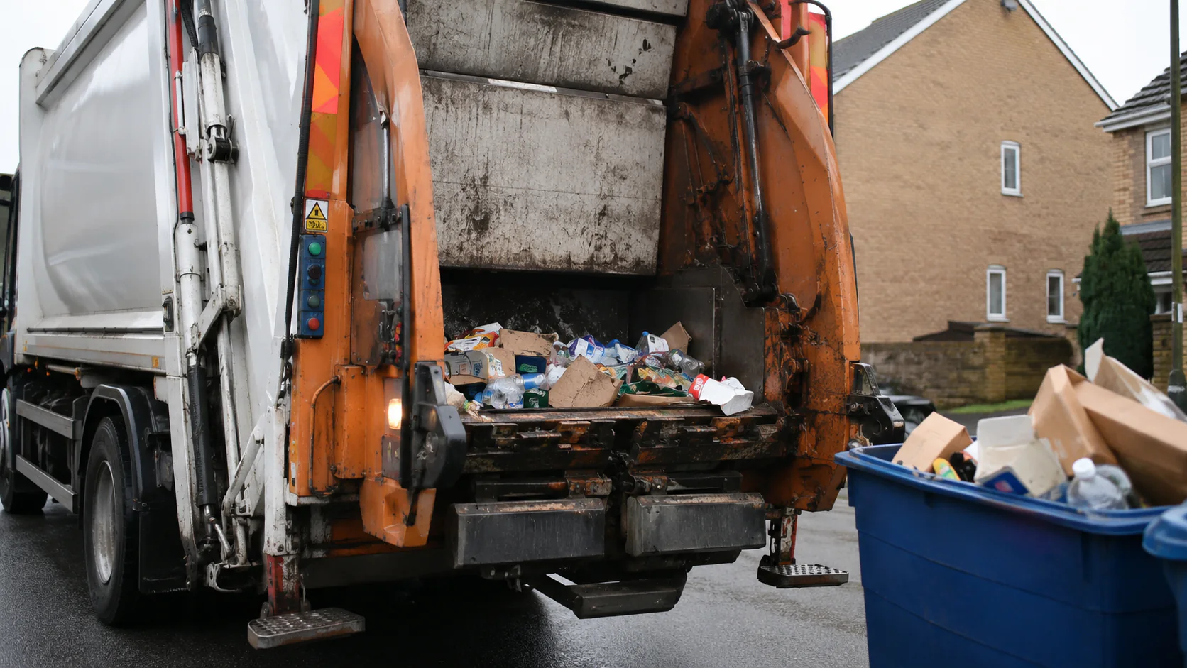 Illustrative refuse collection vehicle with mixed material visible at the hopper