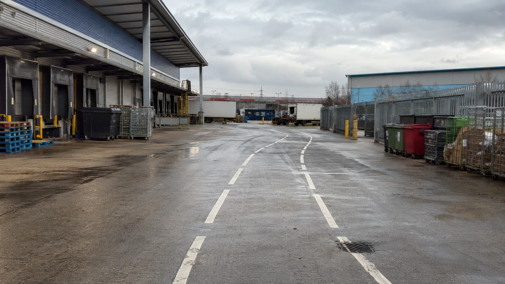 Illustrative logistics yard with a marked central service route and adjacent storage